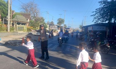 Bhabinkamtibmas-Kolhua-Bantu-Penyeberangan-Anak-MI-Darul-Hijrah-Madani