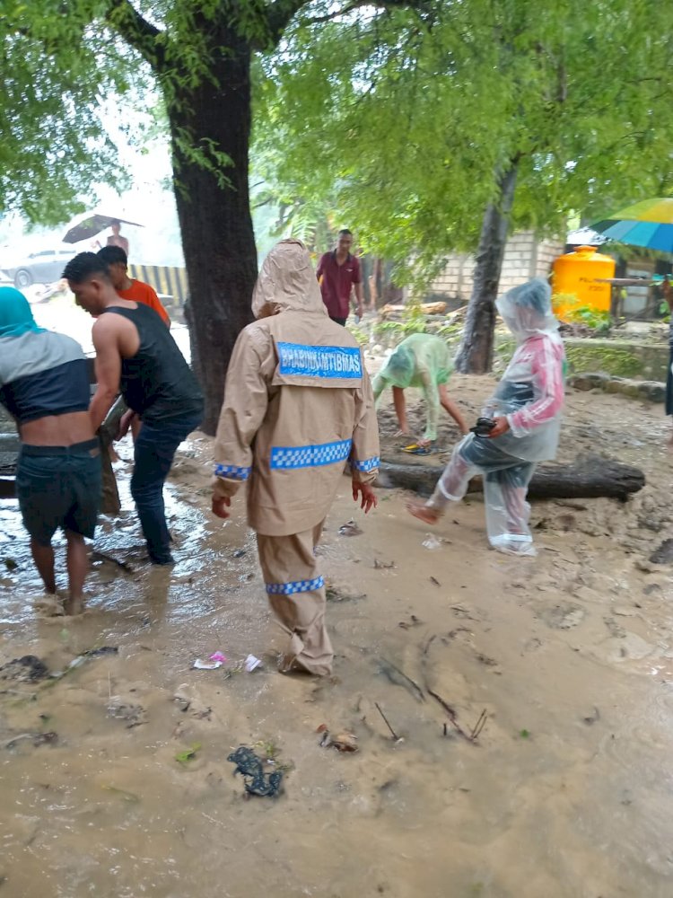 Bhabinkamtibmas Penfui Bantu Warga yang Rumahnya Terendam Banjir